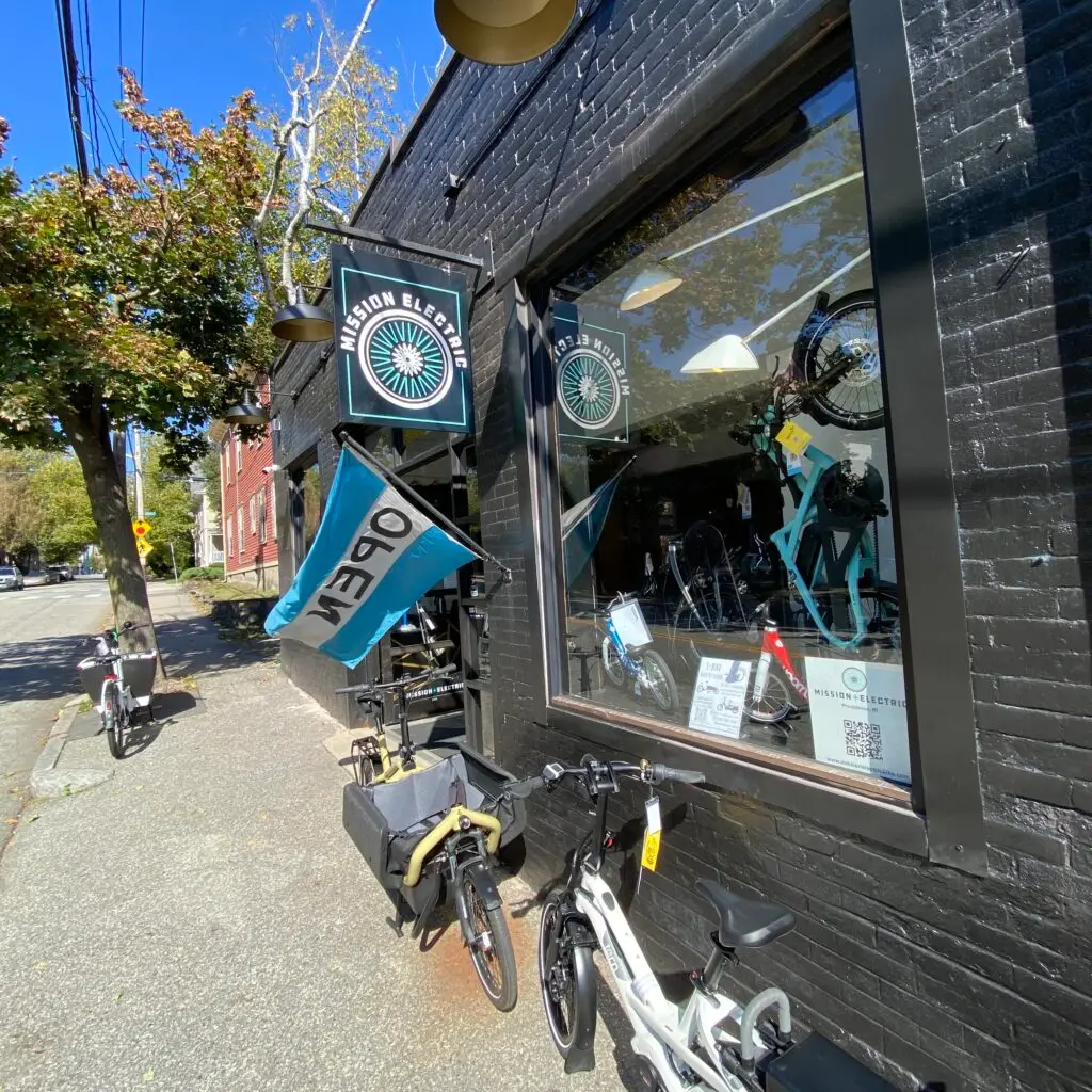 Mission Electric bike shop front on Brook Street in Providence with the teal Open flag out
