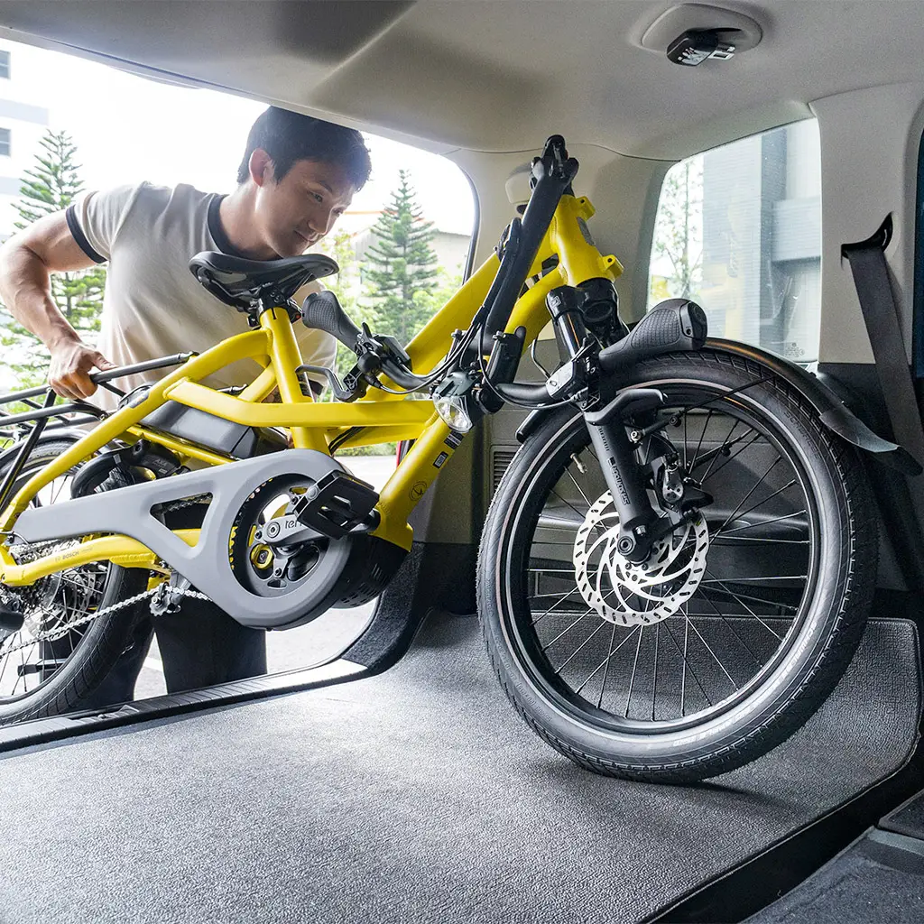 Loading a flat-folded Tern HSD e-cargo bike into a car trunk